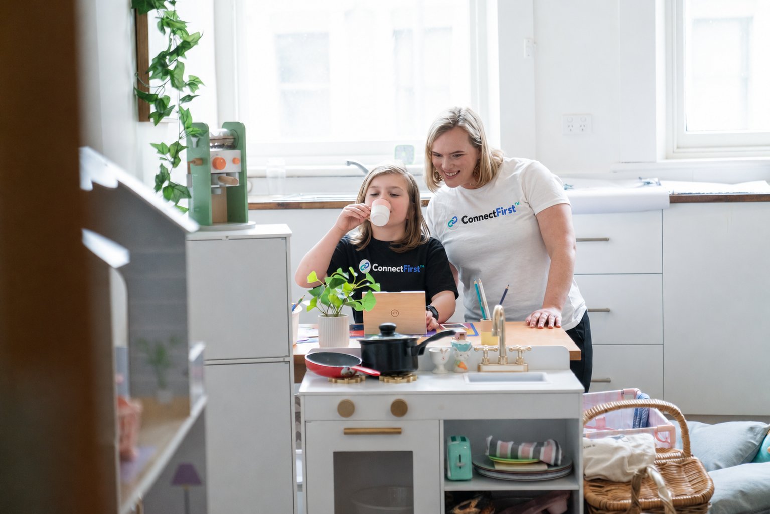 A ConnectFirst early intervention practitioner with a child at a play kitchen