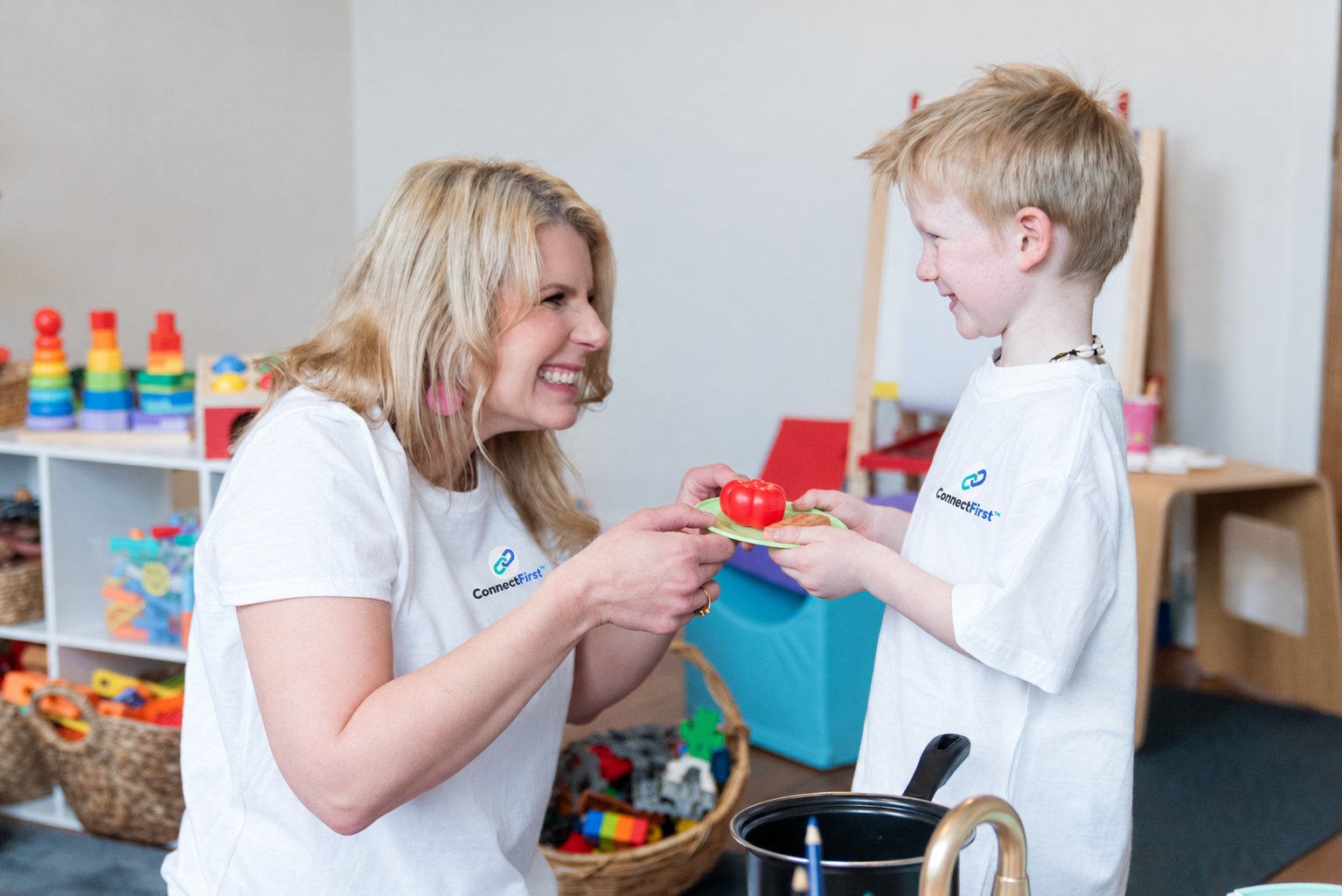 Meg Hughes sharing play food with a young boy