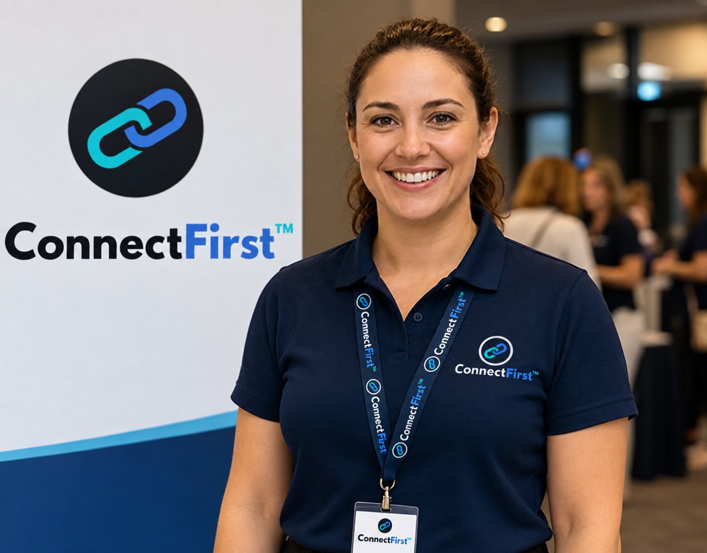 A smiling ConnectFirst team member in a branded polo and lanyard